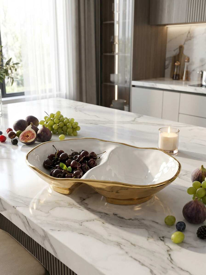 Decorative bowl with fruits on a marble countertop in a kitchen.